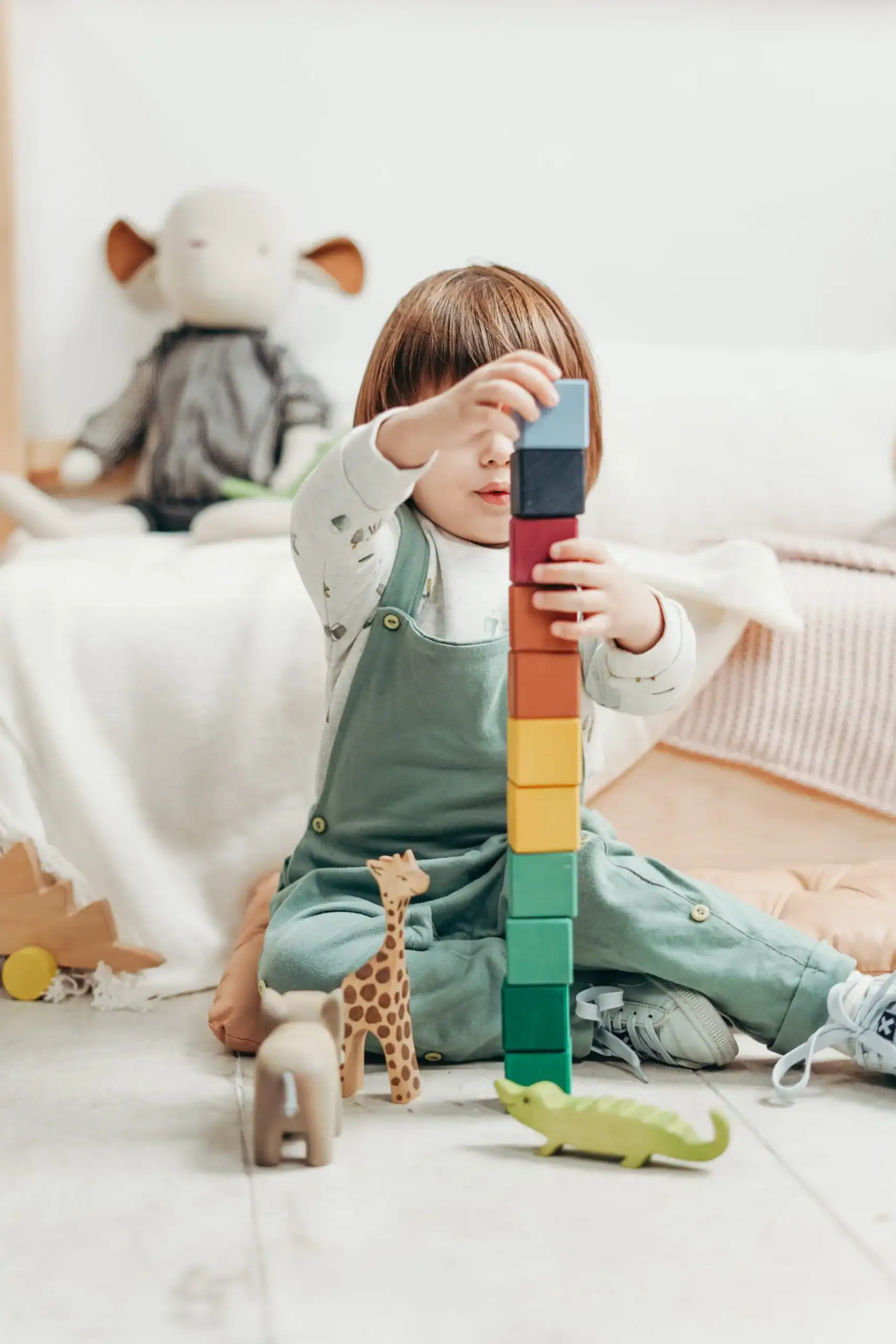 Child playing with block sat on floor at nursery